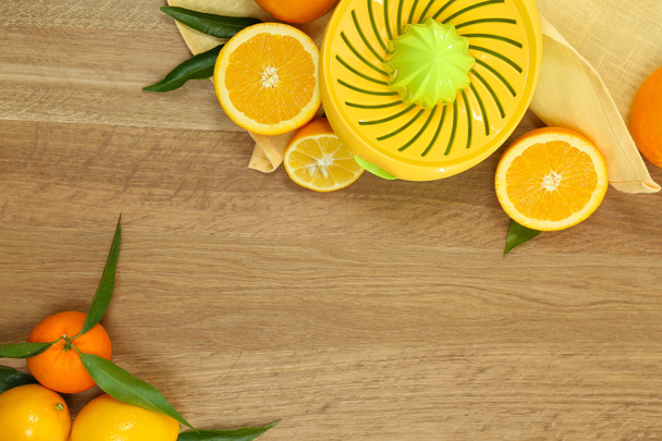Citrus press and fruits on wooden background - Φωτογραφία, εικόνα