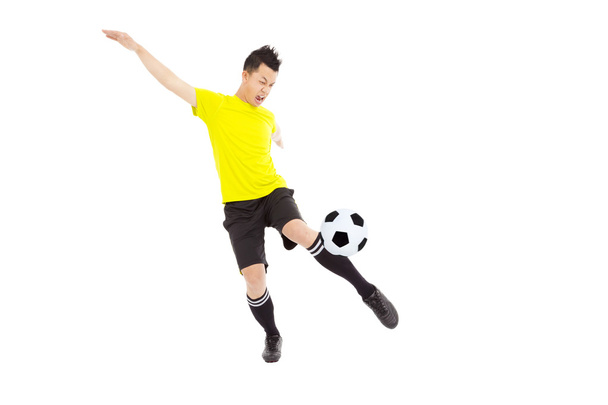 Молодий футболіст штовхає м'яч
 - Фото, зображення