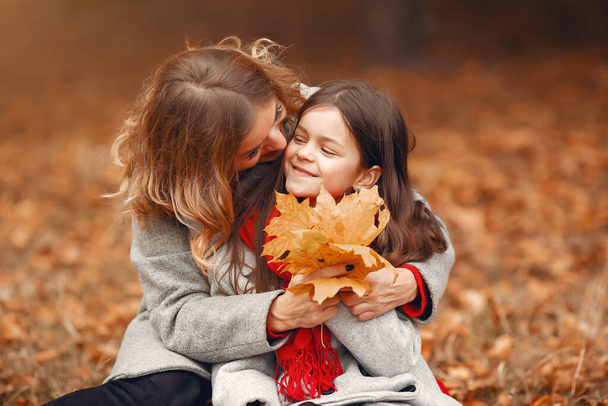 Cute and stylish family in a autumn park - 写真・画像