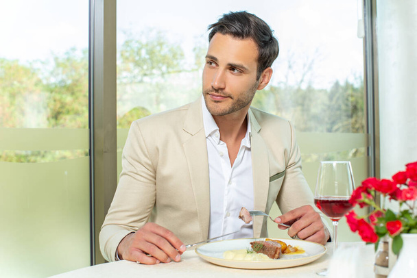 Attractive man having lunch in a hotel restaurant - Foto, afbeelding
