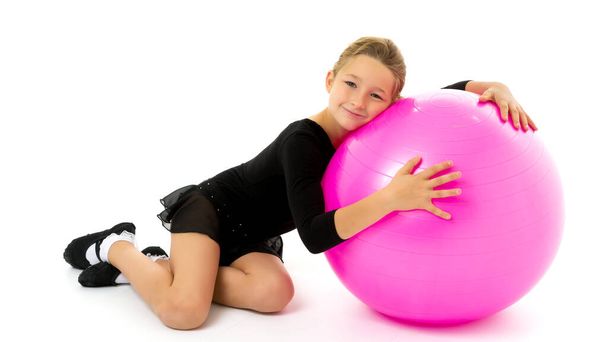 little girl doing exercises on a big ball for fitness. - Фото, изображение