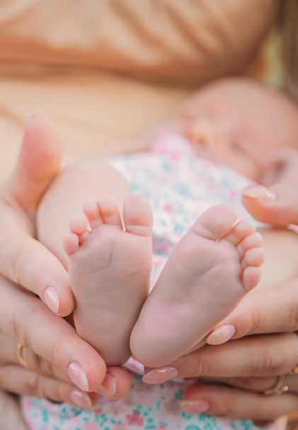 Yeni doğmuş bir bebeğin ayakları annenin ellerinde. Seçici odaklanma. İnsanlar. - Fotoğraf, Görsel