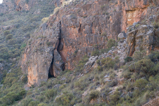 Berglandschap in het zuiden van Spanje, is er een rotswand en de berghelling heeft struiken - Foto, afbeelding