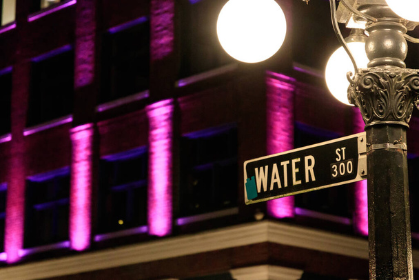 Nahaufnahme des Hinweisschildes zur Water Street in der Nähe der Steam Clock in Gastown, Vancouver, Kanada bei Nacht - Foto, Bild