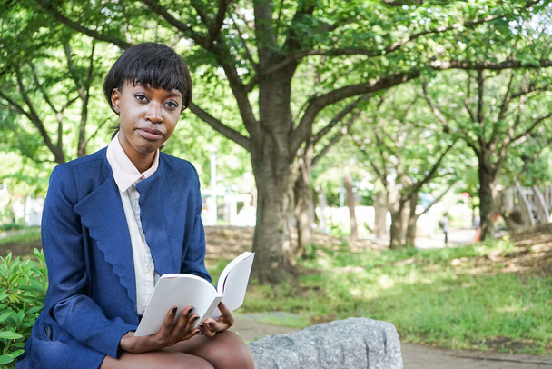 African woman reading a book at park - Fotografie, Obrázek
