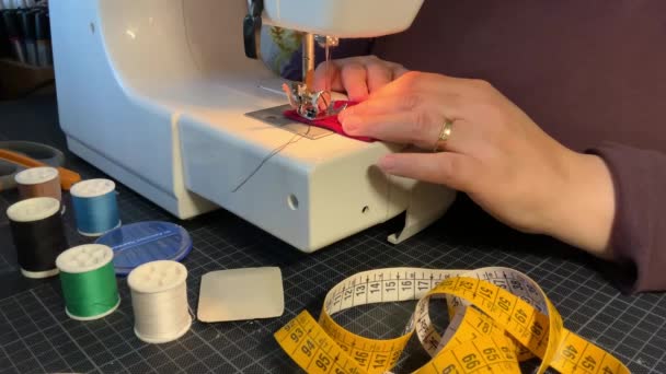Una mujer está trabajando en una máquina de coser, de cerca. Proceso de costura - Metraje, vídeo