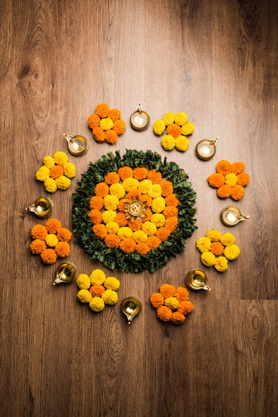 Flower Rangoli for Diwali or Pongal Festival made using Marigold or Zendu flowers and Rose petals over moody or white background, selective focus - Photo, Image