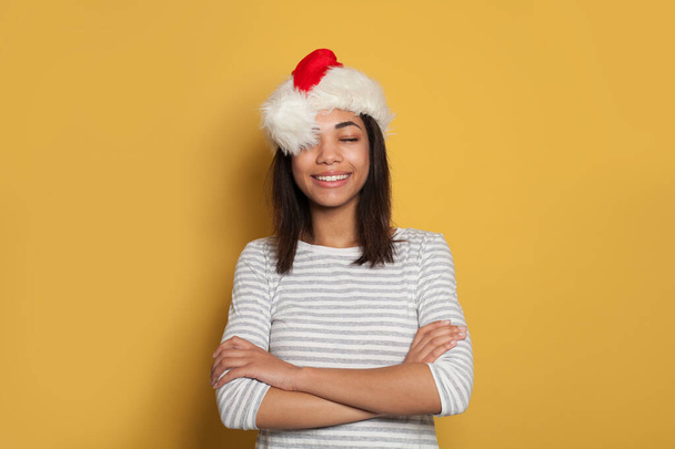 サンタ帽子の幸せな黒女性作る願い上の黄色の背景 - 写真・画像