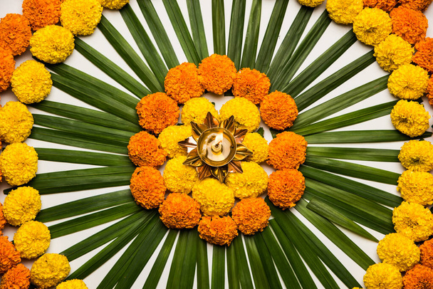 Flower Rangoli for Diwali or Pongal Festival made using Marigold or Zendu flowers and Rose petals over moody or white background, selective focus - Photo, Image