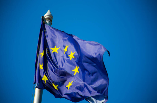 European union flag fluttering against blue sky - Foto, immagini
