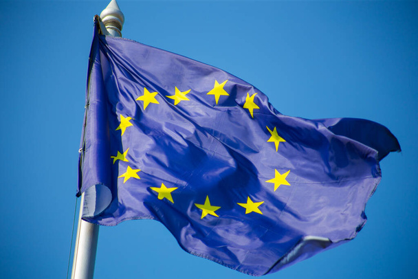 Σημαία της Ευρωπαϊκής Ένωσης κυματίζει στον γαλάζιο ουρανό - Φωτογραφία, εικόνα