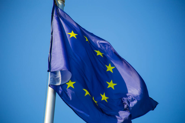 Флаг Европейского союза, развевающийся на фоне голубого неба - Фото, изображение