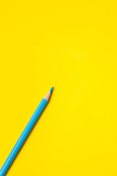 diagonal blue sharp wooden pencil on a bright yellow background, isolated, copy space, mock up - Foto, Imagen