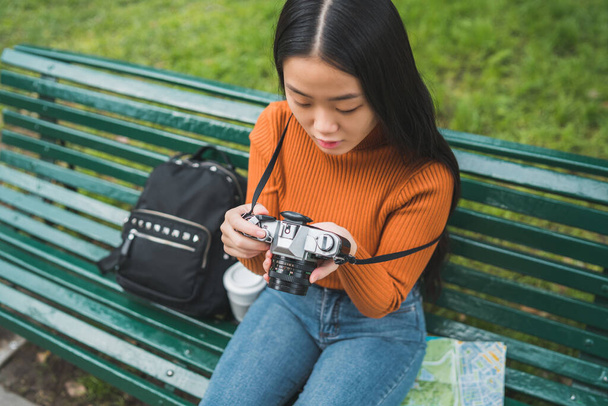 Portrait of young Asian woman using a professional digital camera in the park outdoors. Photography concept. - Photo, image