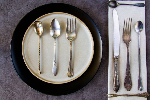 Set stoviglie e piatti, piatti, piatti, coltelli e cucchiai sullo sfondo grigio - Foto, immagini