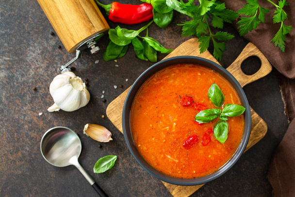 Vegane gesunde Ernährung. Tomatensuppe oder Gazpacho auf einem dunklen Stein- oder Schiefertisch. Flache Lageoberfläche. - Foto, Bild