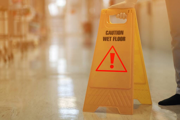 κίτρινο σημάδι της προσοχής αποθεματικό καθαρισμού σε βρεγμένο πάτωμα - Φωτογραφία, εικόνα