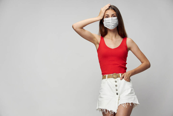 Woman in protective mask against coronavirus posing in studio. - Photo, Image