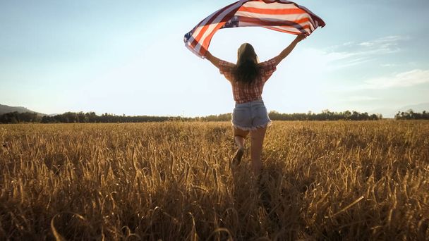 Young woman waves an american flag - Zdjęcie, obraz