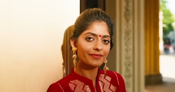 Retrato de una joven hindú con estilo hermosa mujer con punto en la frente y en ropa tradicional sonriendo a la cámara con alegría. Al aire libre. Primer plano de chica feliz bastante sonriente de la India. - Imágenes, Vídeo