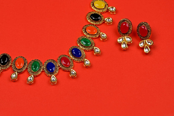 Kırmızı arkaplanlı geleneksel Hint mücevherleri. Çok renkli kolyeler, lüks kadın mücevherleri, Hint geleneksel mücevherleri, düğün mücevherleri. - Fotoğraf, Görsel