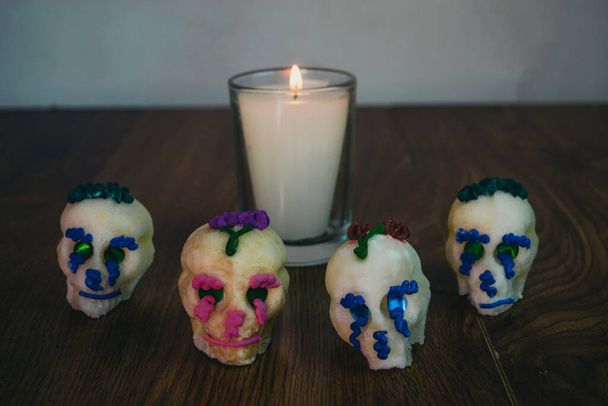 altar con vela encendida junto a calaveras de azúcar, decoración para el día de los muertos. Festividad mexicana - Foto, imagen