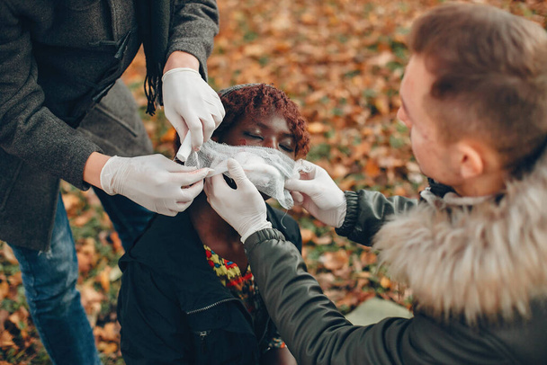 Two boys help a african girl in a autumn park - Foto, Bild