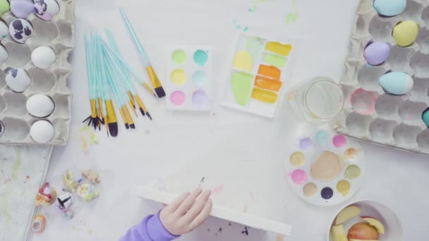 Düz yatıyordu. Küçük kız ve annesi akrilik boyayla Paskalya sanat projesini boyuyorlar.. - Video, Çekim