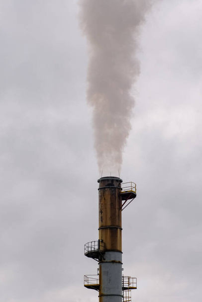 An industrial smoke stack emits pollution into the atmosphere. - Photo, Image