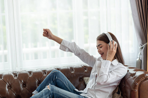 Portret van jonge Aziatische vrouw genieten van het luisteren naar muziek met koptelefoon, gelukkig en ontspannen tijd - Foto, afbeelding