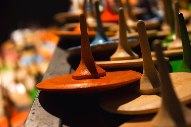 Крупный план красочных расписных деревянных игрушек ручной работы - колышек или вихрей в качестве творческого фона. Развлечения или игрушки ручной работы - Фото, изображение