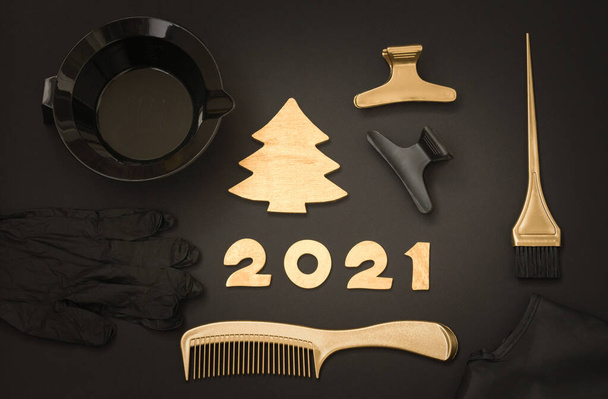 Accessories for hair coloring, numbers 2021 and a Golden Christmas tree. Black and gold color items, new year theme for hairdressers - Photo, Image