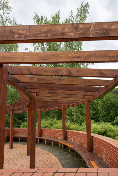 Nowa okrągła drewniana pergola z długą ławką w parku - Zdjęcie, obraz