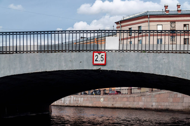 eine niedrige Brücke mit einem Schild, das ihre Höhe anzeigt - Foto, Bild