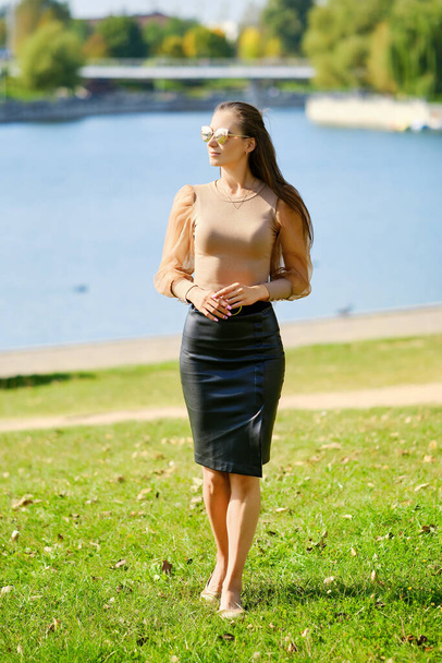 Beautiful woman walks in the park near the river - Φωτογραφία, εικόνα
