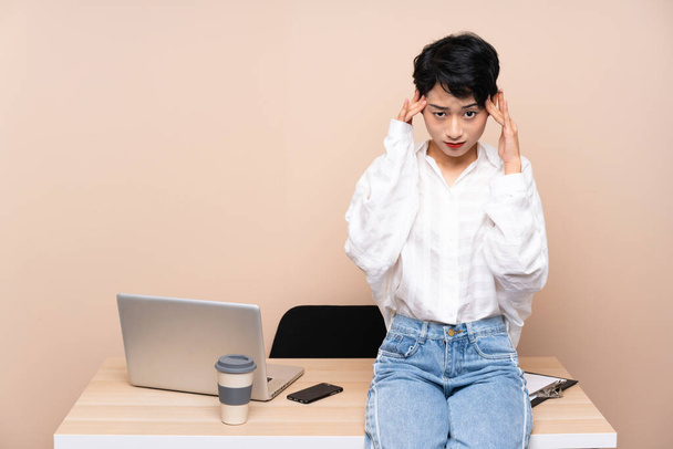 Jonge business Aziatisch meisje op haar werk ongelukkig en gefrustreerd door iets. Negatieve gezichtsuitdrukking - Foto, afbeelding