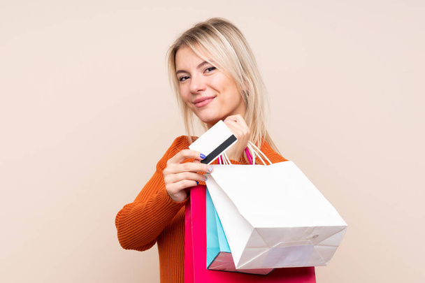 Junge blonde Frau mit Einkaufstaschen und Kreditkarte - Foto, Bild