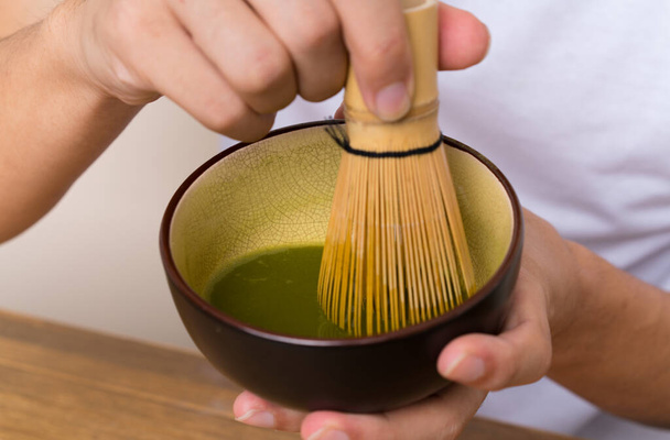 Young asian man with matcha tea in a table - Photo, Image