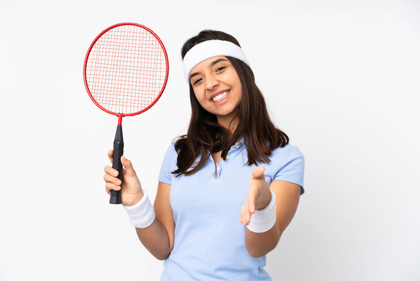 Mladý badminton hráč žena přes izolované bílé pozadí třesoucí se ruce pro uzavření hodně - Fotografie, Obrázek