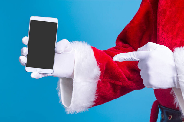 Santa Claus pointing the mobile phone with his finger ready for Christmas, Christmas card - Φωτογραφία, εικόνα