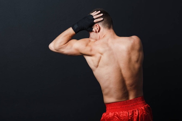 Sportman muay thai man bokser houding ad elleboog punch op zwarte achtergrond - Foto, afbeelding