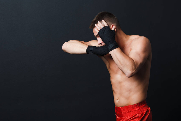 Sportsman muay thai man boxer stance ad elbow punch at black background - Foto, afbeelding