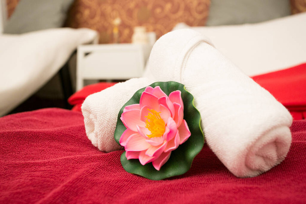 Saubere Handtücher auf dem Bett im Wellnessraum - Foto, Bild