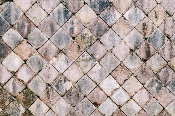 Πλάγια πλακόστρωση πέτρες με ένα διαμάντι σχήμα από μια φυσική πέτρα του γκρι χρώμα close-up. - Φωτογραφία, εικόνα