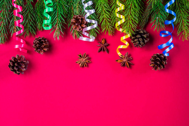 Roter Weihnachtshintergrund mit Fichtenzweigen, Zapfen und Schlange - Foto, Bild