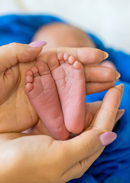 Yeni doğmuş bebek ayakları annenin ellerinde. Seçici odaklanma. insanlar. - Fotoğraf, Görsel