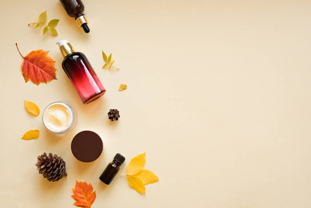 Autumn Skin Care products and autumn leaves on yellow background, flat lay, copy space.  Seasonal beauty routine and organic cosmetic concept. - Fotografie, Obrázek