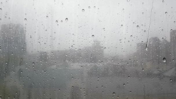 Nahaufnahme von Wassertropfen auf Glas. Während des Herbstregens fallen große Tropfen auf die Fensterscheibe und strömen tagsüber gegen den Himmel. Herbst- und Regenzeit. Schlechtes Wetter - Filmmaterial, Video