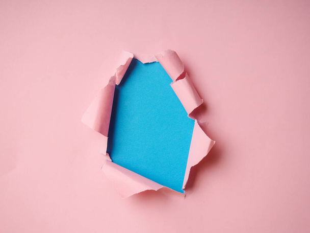 Roztrhané papírové díry s růžovým a modrým pozadím. - Fotografie, Obrázek