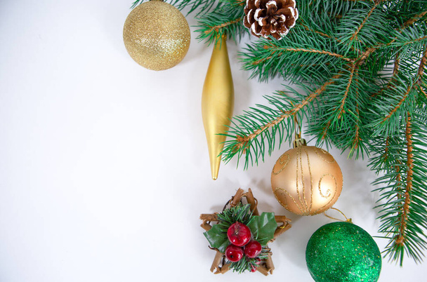 Větve vánočního stromečku s hračkami na bílém pozadí jako rámeček nebo šablona pro vánoční přání - Fotografie, Obrázek